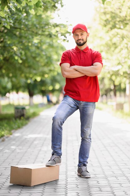 Front view young delivery man posing outdoors