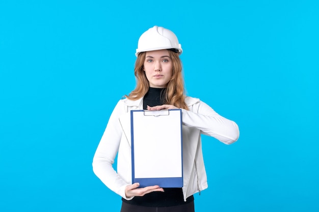 Front view young female architect holding file note on blue