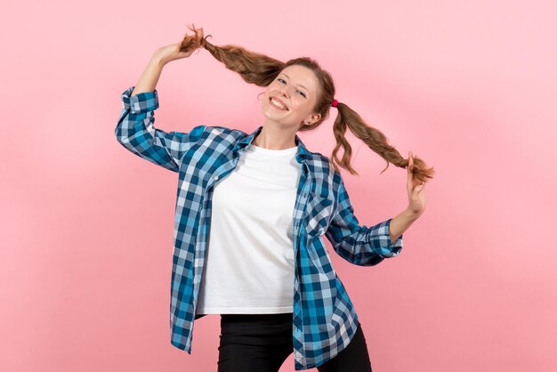 Front view young female in blue checkered shirt posing and smiling on pink wall woman emotions model fashion girls color