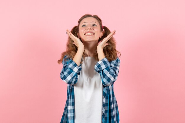 Front view young female in blue checkered shirt posing with slight smile on pink background woman emotions model fashion girls color