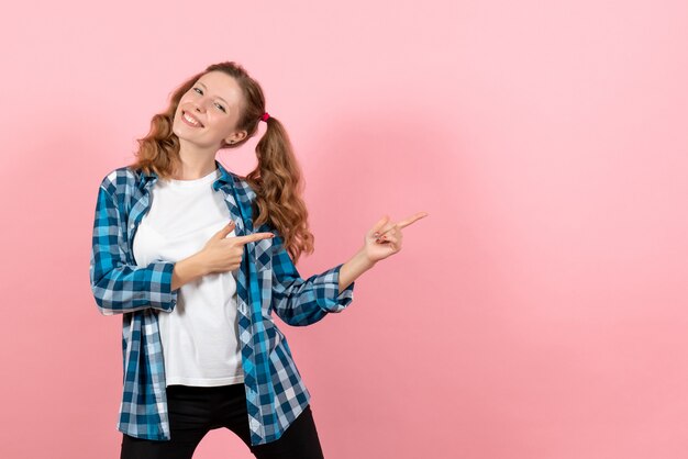 Front view young female in checkered shirt posing with smile on pink background woman kid youth color emotions model