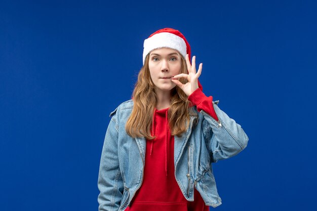 Front view young female closing her mouth on blue background christmas emotion color