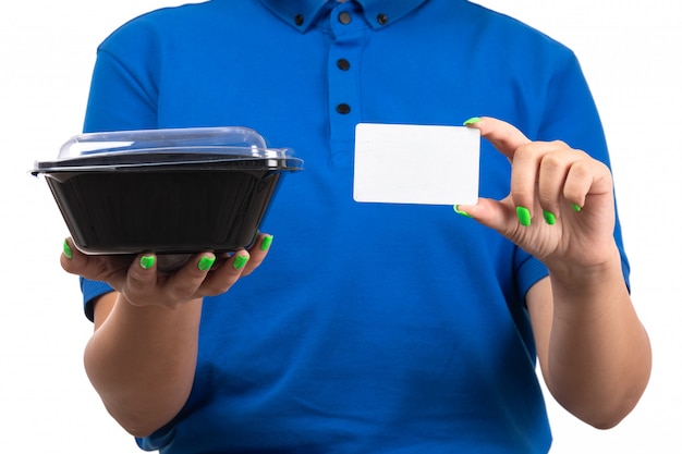 A front view young female courier in blue uniform holding food bowl and white card