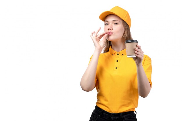 A front view young female courier female worker of food delivery service holding coffee cup and showign tasty sign on white