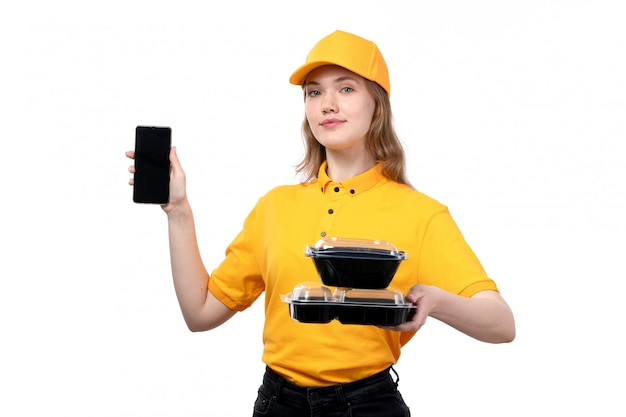 Free photo a front view young female courier female worker of food delivery service holding smartphone and food bowls on white