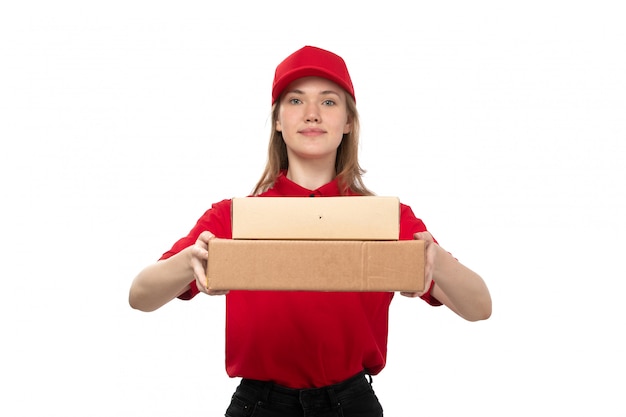 A front view young female courier female worker of food delivery service smiling holding boxes with food on white