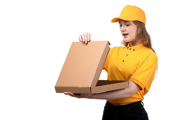 A front view young female courier female worker of food delivery service smiling holding food package on white