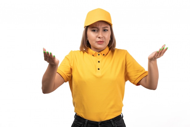 A front view young female courier in yellow uniform posing