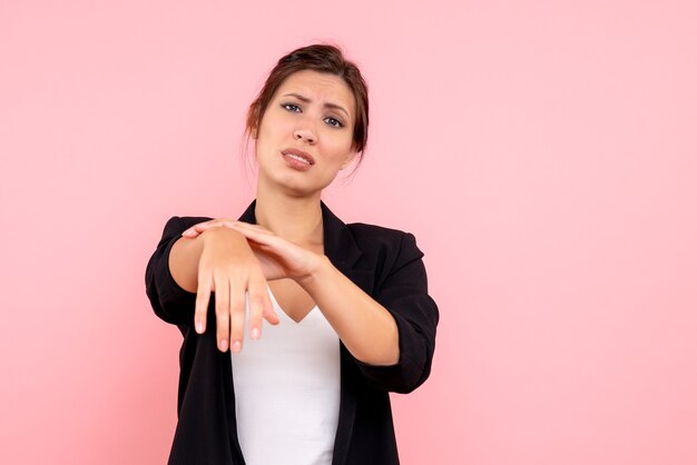 Front view young female in dark jacket with hurt arm on pink background