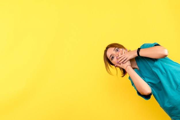 Free photo front view of young female doctor shocked on yellow wall