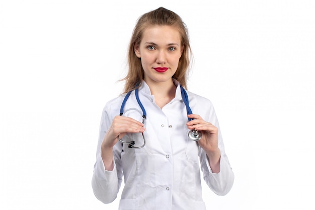 Free photo a front view young female doctor in white medical suit with stethoscope smiling on the white