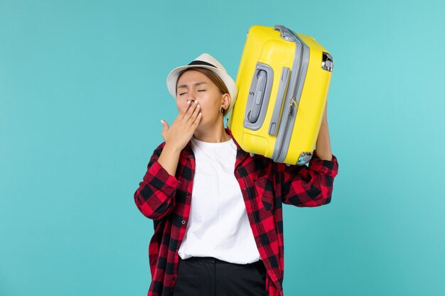 Front view young female going in vacation with her big bag yawning on blue space