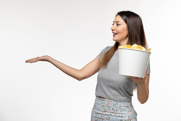 Front view young female holding chips while watching movie on white surface