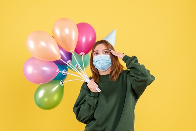 Free photo front view young female holding colorful balloons