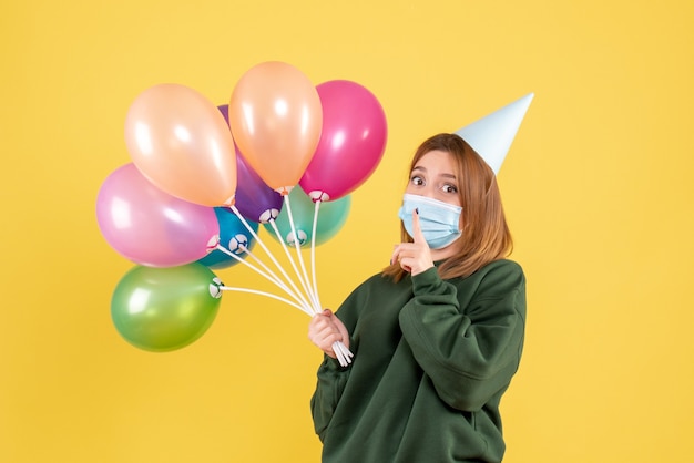 Front view young female holding colorful balloons