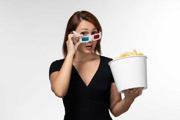 Front view young female holding potato chips in d sunglasses on light-white surface