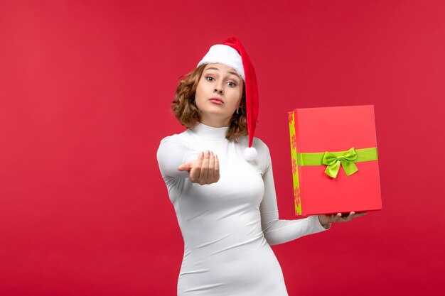 Free photo front view of young female holding present on red