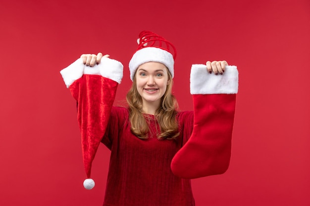 Free Photo front view young female holding red big sock and cap, holiday red christmas