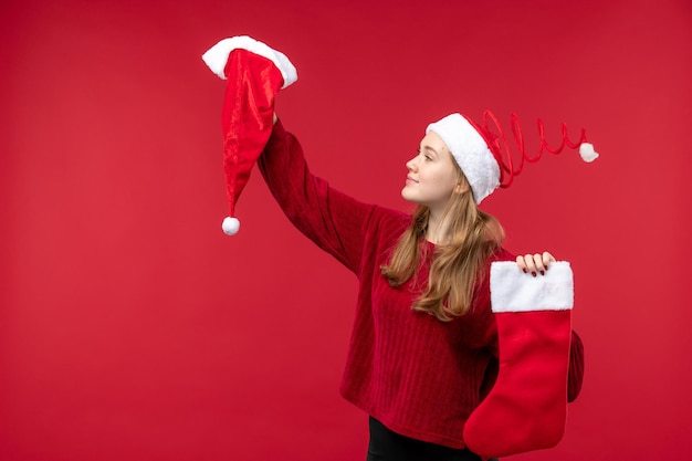 Free Photo front view young female holding red big sock and cap, holidays red christmas