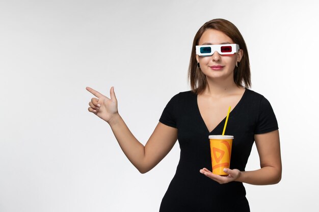 Front view young female holding soda in d sunglasses with smile on white surface