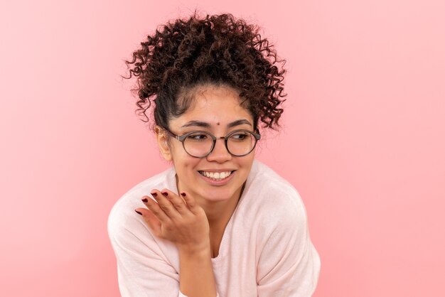 Front view of young female laughing on pink