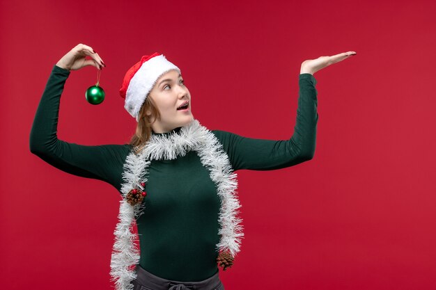 Free Photo front view young female posing with new year attributes on a red background