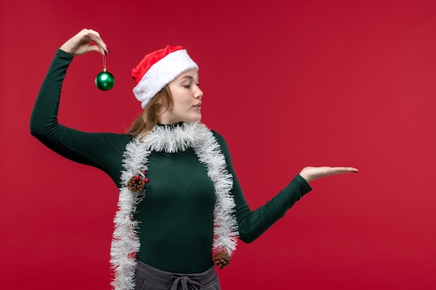 Free photo front view young female posing with new year attributes on red background