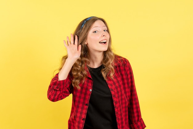 Front view young female in red checkered shirt listening closely to something on yellow background woman human emotion model fashion girl