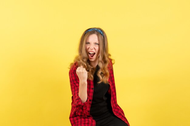 Front view young female in red checkered shirt posing and rejoicing on yellow background girls emotions color human model woman