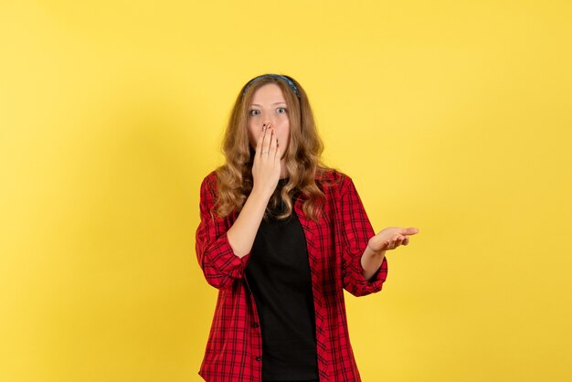 Front view young female in red checkered shirt standing on the yellow background girls human color model woman