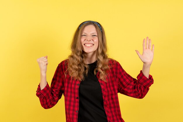 Front view young female in red checkered shirt standing on yellow background girls human color model woman