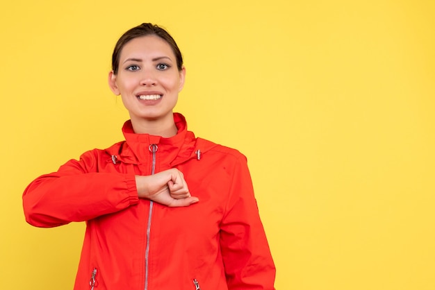 Front view young female in red coat on yellow background