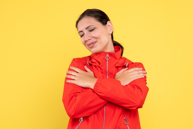 Free photo front view young female in red coat on yellow background