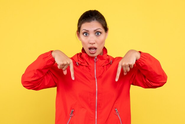 Front view young female in red coat on yellow background