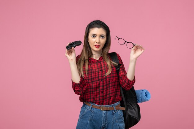 Front view young female in red shirt with binoculars on pink background woman photo model