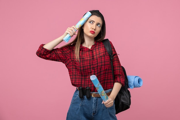 Front view young female in red shirt with maps on the pink background color woman human