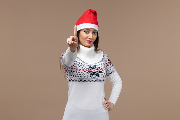 Front view young female showing number on brown background holiday christmas emotion