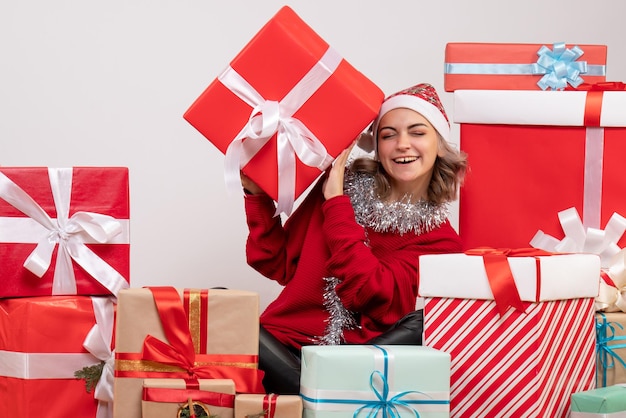 Front view young female sitting around christmas presents