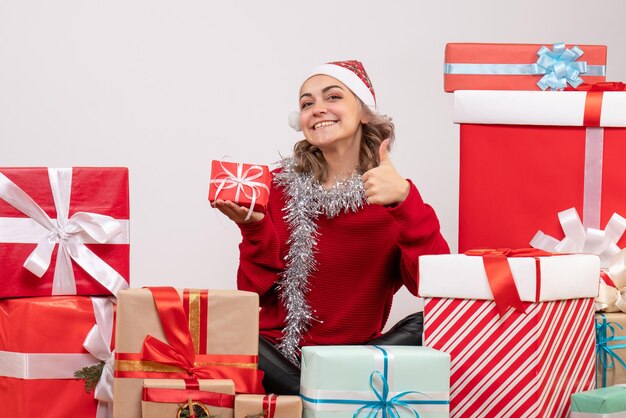 Front view young female sitting around christmas presents