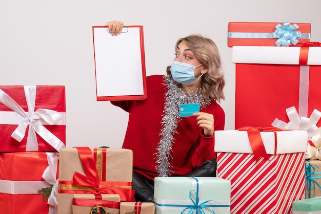 Free photo front view young female sitting around presents with bank card