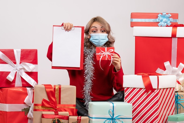 Front view young female sitting around presents with note