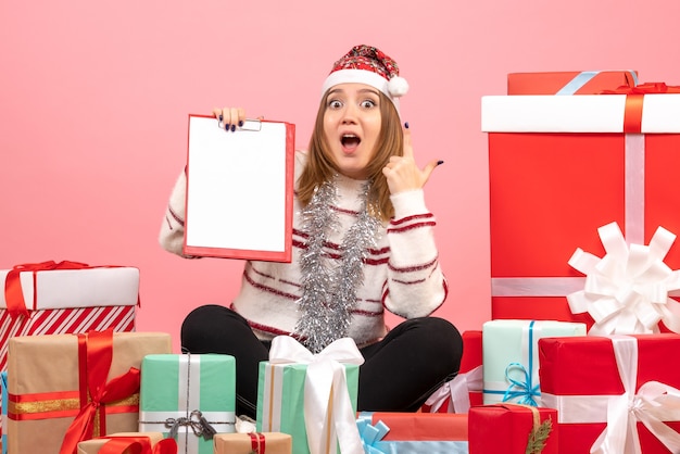 Free Photo front view young female sitting around xmas presents with file note