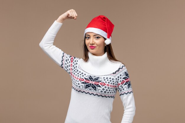 Front view young female smiling and flexing on brown background emotion christmas new year