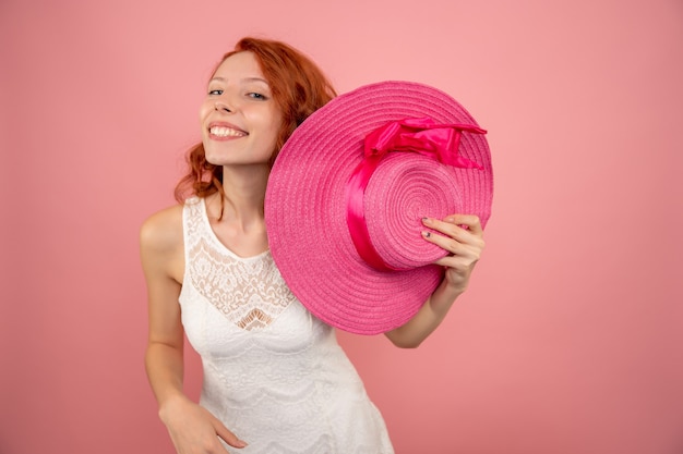 Front view of young female smiling on pink wall