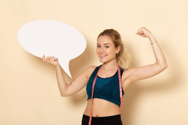 Front view young female in sport outfit holding white sign