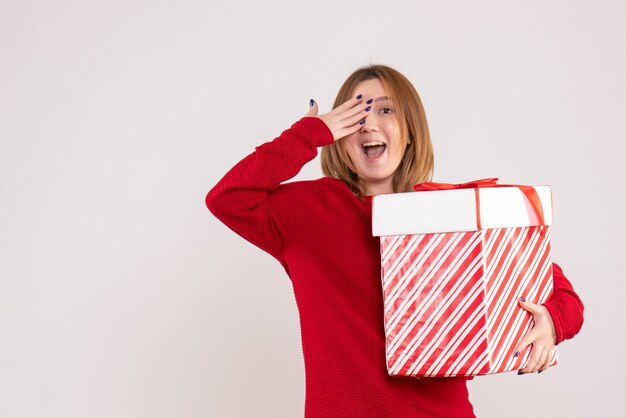 Front view young female standing with present box in her hands