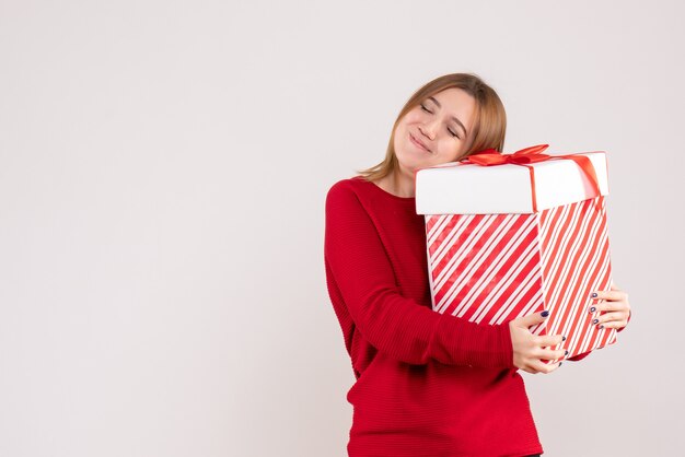 Front view young female standing with present box in her hands