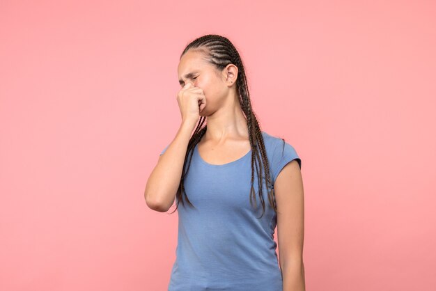 Front view of young female stucking her nose on pink