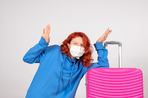 Free photo front view of young female tourist with pink bag in mask on a white wall