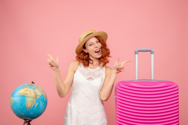 Free Photo front view of young female tourist with pink bag on pink wall